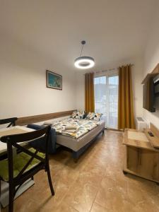 um quarto com uma cama, uma mesa e uma janela em Apartmani Resna Budva em Budva