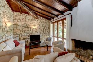 a living room with couches and a stone wall at Villa Maria by Garda FeWo in Moniga