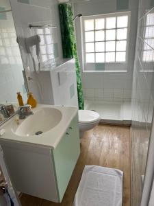 a white bathroom with a sink and a toilet at HOTEL RESTAURANT LA COTE REVEE in Leucate