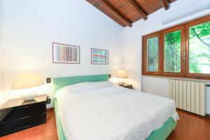 a bedroom with a bed and two lamps and a window at Villa Maria by Garda FeWo in Moniga +30 photos
