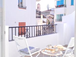 two white chairs and a table on a balcony at Noctua 012 Estepona Oldtown 3 in Estepona