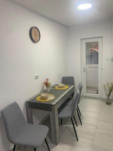 a dining room table with chairs and a clock on a wall at Bia's apartament in Râşnov +12 photos