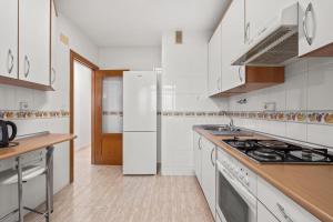 a white kitchen with a stove and a refrigerator at Acag 135 in Orihuela +16 photos