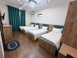 a room with three beds and a chandelier at Soro Hotel in Dushanbe
