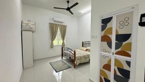 a bedroom with a crib and a bed in a room at AS Suria Homestay Banglo 1 Tingkat Kota Bharu in Kota Bharu