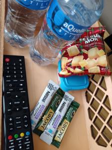 een tafel met een afstandsbediening en een fles water bij 179 Guesthouse on Mountain Drive in Mbabane