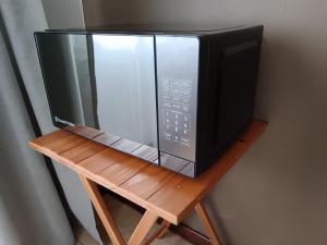 een magnetron op een houten standaard bij 179 Guesthouse on Mountain Drive in Mbabane