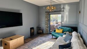 a living room with a couch and a tv at 1 Bossiney House - Bude Cornwall in Bude
