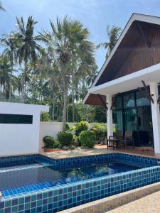 ein Swimmingpool vor einem Haus mit Palmen in der Unterkunft Pool villa Aonang 2 room 2 bedroom in Ao Nang Beach