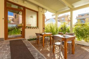 two tables and chairs on the patio of a building at Guest House Aura - Lumys Fiumicino in Fiumicino