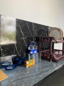 a counter with bottles of water and glasses on it at The Rosemary House in Weligama +15 photos
