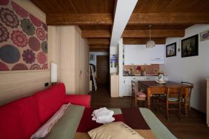 a living room with a red couch and a kitchen at Mono 1400 in Limone Piemonte