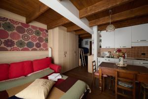 a living room with a red couch and a kitchen at Mono 1400 in Limone Piemonte