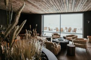 Una habitación con sillas y una mesa y una ventana grande. en Hótel Jökulsárlón - Glacier Lagoon Hotel, en Gerdi