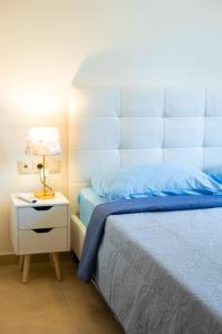 a bedroom with a bed and a night stand with a lamp at Eukalyptos 3BD apartment with yard in Chersonisos in Hersonissos