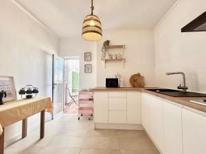 een keuken met witte kasten en een spoelbak bij Casa titamari in Casarabonela