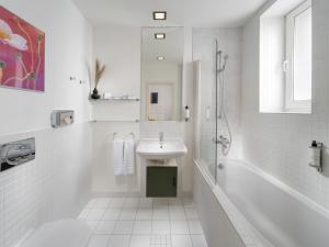 ブラチスラヴァにあるMamaison Residence Sulekova Bratislavaの洗面台とシャワー付きの白いバスルーム