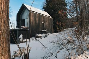 a small wooden cabin in the snow with trees at Rest Hill -Domek z balią i sauną - Everslow in Sosnówka