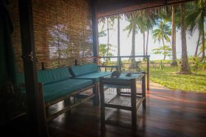 a living room with a green couch and a table at Ferra Resort Siargao in General Luna