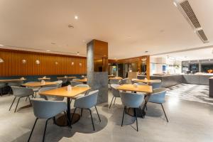 ein Restaurant mit Holztischen und blauen Stühlen in der Unterkunft Holiday Inn Express Yichang Riverside by IHG in Yichang