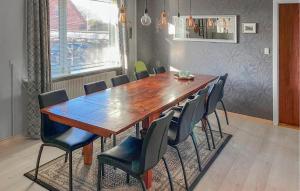 3 Bedroom Cozy Home In Bøvlingbjerg في Bøvlingbjerg: غرفة طعام مع طاولة وكراسي خشبية