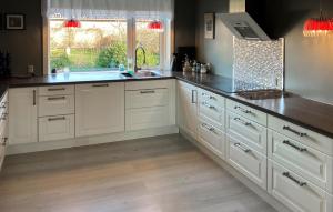 3 Bedroom Cozy Home In Bøvlingbjerg في Bøvlingbjerg: مطبخ بخزائن بيضاء ومغسلة ونافذة