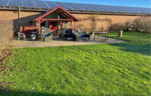 3 Bedroom Cozy Home In Bøvlingbjerg في Bøvlingbjerg: منزل فيه كراسي وطاولة في ساحة