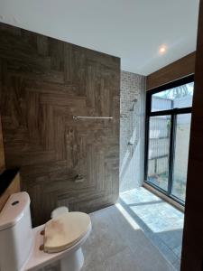 ein Bad mit einem WC und einer Holzwand in der Unterkunft Pool villa Aonang 2 room 2 bedroom in Ao Nang Beach