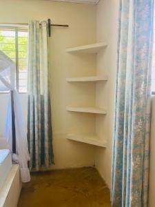 ein Zimmer mit Regalen in einem Schlafzimmer mit Fenster in der Unterkunft Double room with shared bathroom #2 in Paje