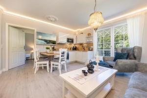 een keuken en woonkamer met een tafel en stoelen bij Villa Strandblick 6 in Zingst