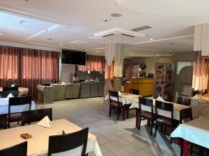 a restaurant with tables and chairs and a kitchen at Hotel Amine in Sfax
