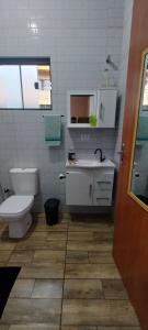 a bathroom with a white toilet and a sink at Apê Estúdio Rodrigues 01 in Paranaíba