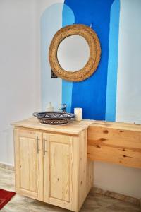 a bathroom with a wooden vanity with a mirror at Onda Surf in Taghazout