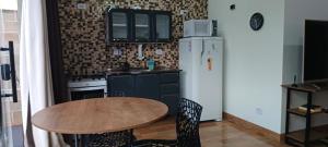 a kitchen with a table and a refrigerator at Apê Estúdio Rodrigues 01 in Paranaíba