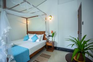 a bedroom with a bed with a canopy at Sleeper Wood Villa in Unawatuna