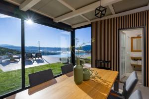 a dining room with a table and a large window at Villa with Private Pool & Lake View near Motovun, Casa Mille Olivi Heritage in Buzet