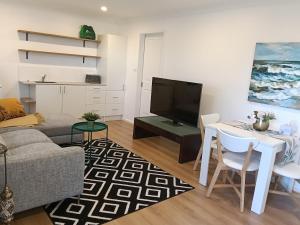 una sala de estar con un sofá y una mesa en Peaceful Retreat with Private Entry AC WiFi Suite, 