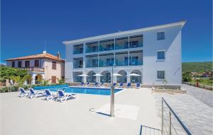 un grande edificio bianco con piscina e sedie di Stunning Apartment In Punat - Cki744 a Punat