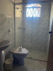 Un baño con ducha, inodoro y lavabo. en Pousada Doce Vida, en Campos do Jordão