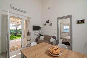 una sala de estar con una mesa y un sofá en Casa vacanza Cala Saccaia, en Isola della Bocca
