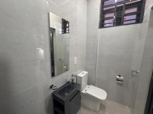 a bathroom with a toilet and a sink and a mirror at La Villa Petite in Lapaz