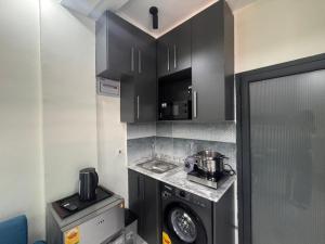 a small kitchen with a washing machine and a microwave at La Villa Petite in Lapaz