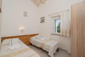 Un dormitorio con dos camas y una ventana. en Casa vacanza Cala Saccaia, en Isola della Bocca