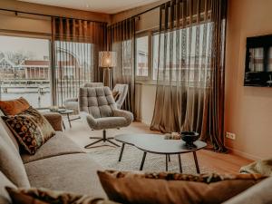 a living room with a couch and a chair and a table at Houseboat Uitgeest XL | 6 people in Uitgeest