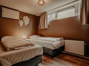a bedroom with two beds and a window at Houseboat Uitgeest XL | 6 people in Uitgeest