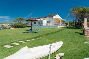 un barco en el césped frente a una casa en Casa vacanza Cala Saccaia, en Isola della Bocca