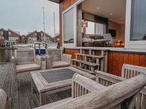 a group of benches on a dock with a boat at Houseboat Uitgeest XL | 6 people in Uitgeest