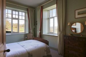 Wesleyan Bolton Abbey Estate في أبليتريويسك: غرفة نوم بسرير ونوافذ ومرآة
