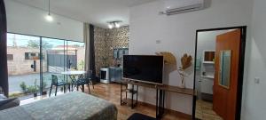a living room with a television and a table with chairs at Apê Estúdio Rodrigues 01 in Paranaíba