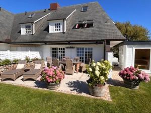 un patio con sedie e fiori di fronte a una casa di LITZKOW 16103 ad Archsum